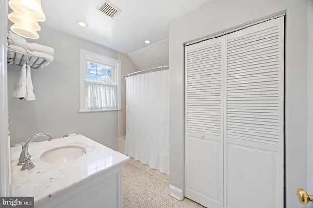 bathroom featuring vanity, recessed lighting, visible vents, and a closet