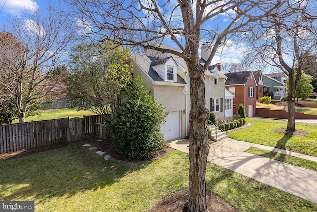 view of side of property with fence, a yard, an attached garage, a residential view, and brick siding