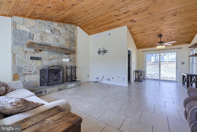 tiled living area with visible vents, a stone fireplace, and wooden ceiling