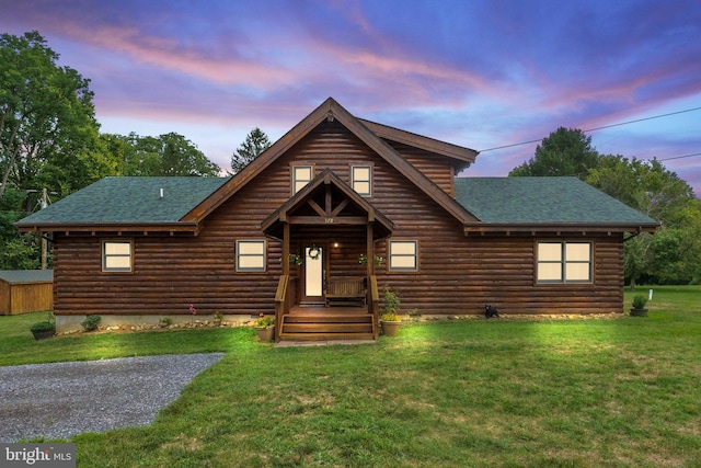 log home with a front lawn, log siding, and a shingled roof