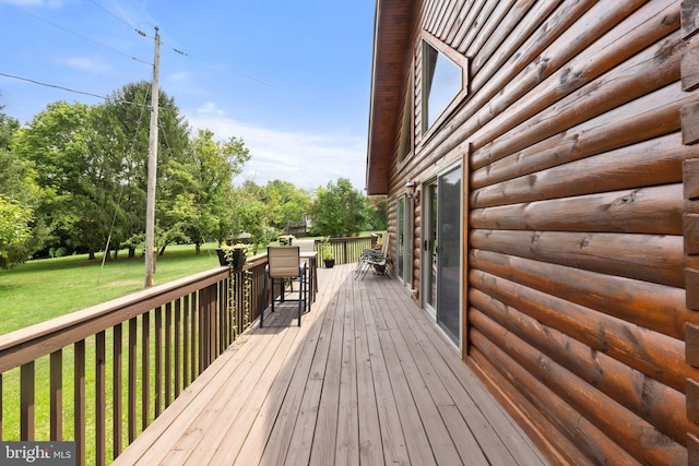 wooden terrace featuring a lawn