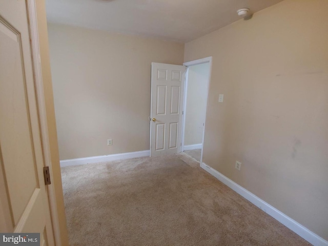 carpeted empty room with baseboards