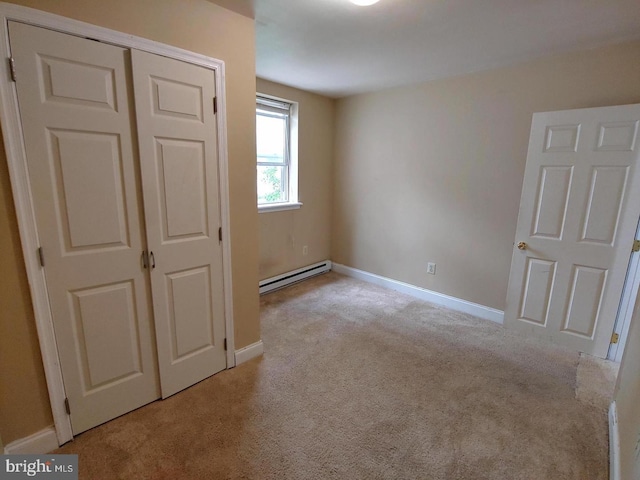 unfurnished bedroom featuring baseboard heating, baseboards, and carpet floors