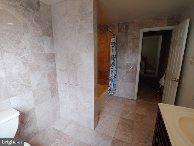 full bathroom with shower / bath combination with curtain, toilet, vanity, and tile walls