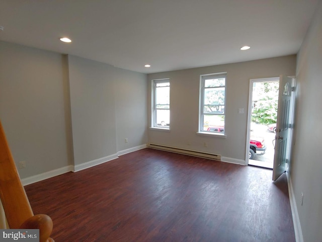 foyer entrance featuring dark wood-style floors, a healthy amount of sunlight, baseboards, and baseboard heating