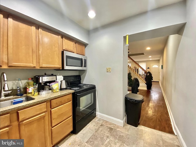 kitchen featuring a sink, stainless steel microwave, recessed lighting, black / electric stove, and baseboards