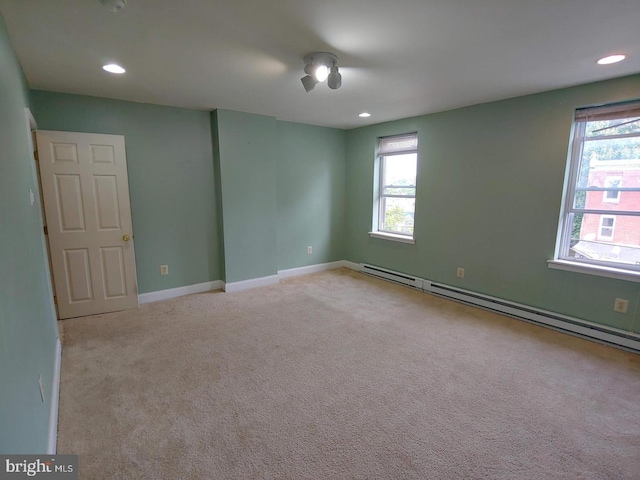 empty room with recessed lighting, baseboard heating, plenty of natural light, and carpet floors