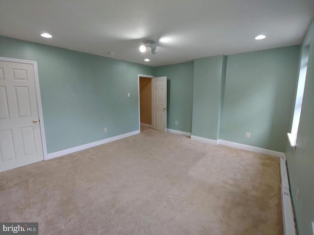 unfurnished room with recessed lighting, baseboards, baseboard heating, and light carpet