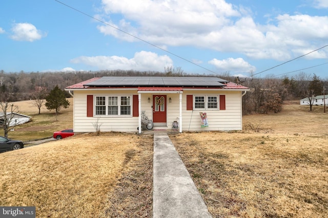 bungalow featuring solar panels and a front lawn