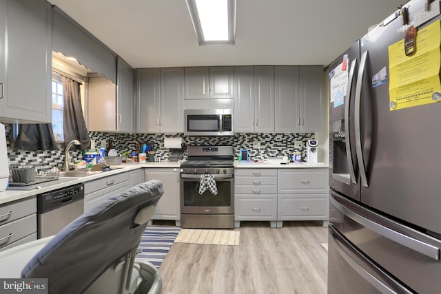 kitchen featuring gray cabinets, appliances with stainless steel finishes, and a sink