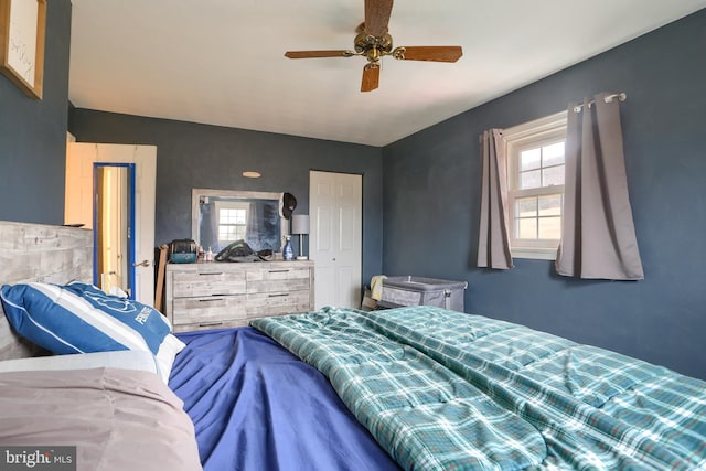 bedroom with lofted ceiling, multiple windows, and a ceiling fan