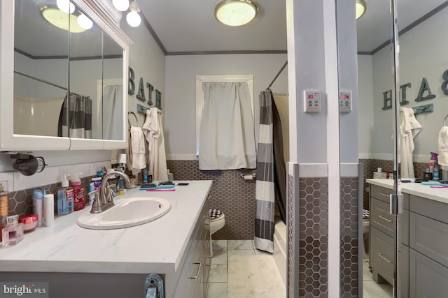 full bathroom with vanity, tile walls, wainscoting, and crown molding