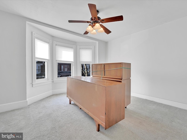 office area featuring light colored carpet, baseboards, and ceiling fan