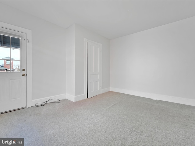 carpeted spare room featuring baseboards