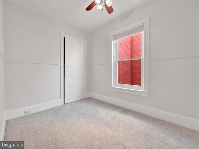 empty room featuring baseboards, carpet floors, and ceiling fan