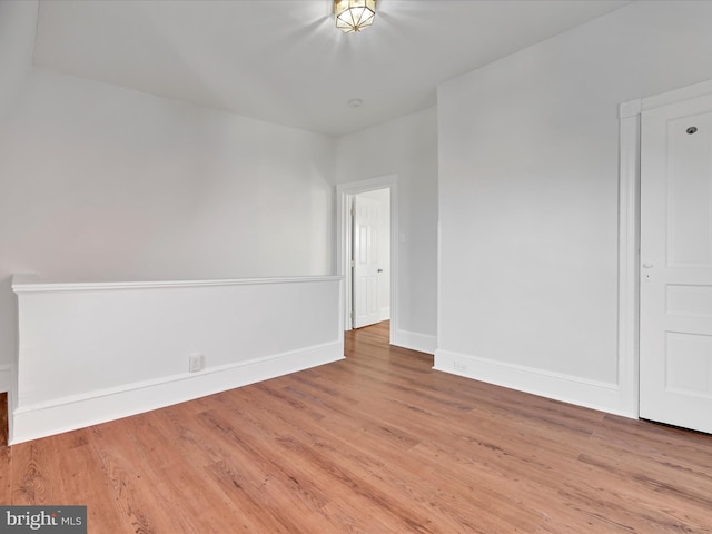 empty room with light wood-type flooring and baseboards