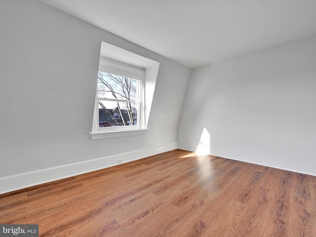 spare room with baseboards and wood finished floors