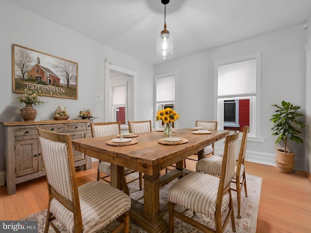 dining area with baseboards and light wood-style floors