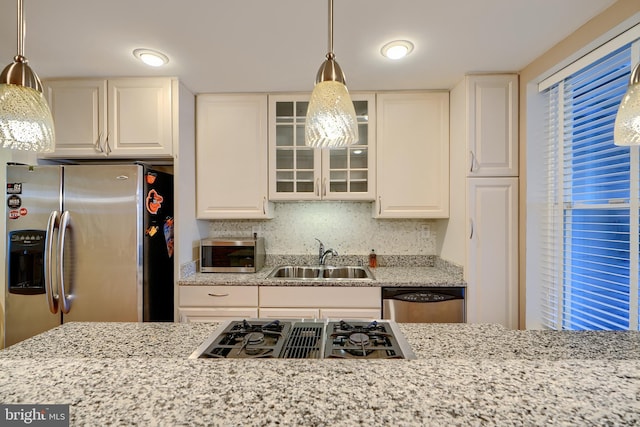 kitchen with a sink, glass insert cabinets, appliances with stainless steel finishes, and white cabinetry