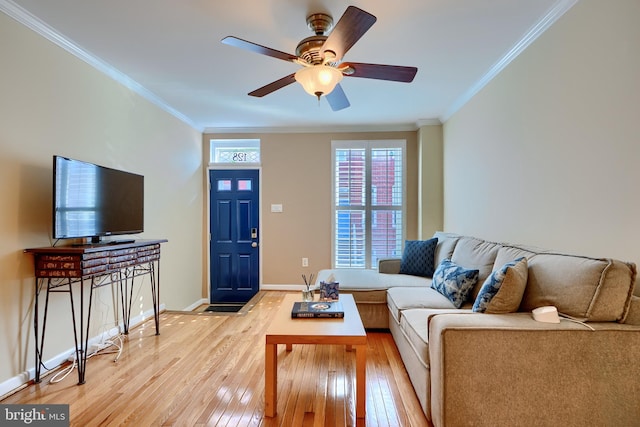 living room with light wood-type flooring, baseboards, ceiling fan, and crown molding