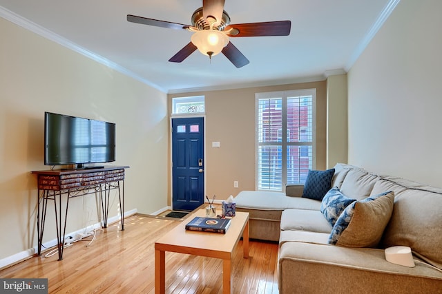 living area with light wood-style flooring, a ceiling fan, crown molding, and baseboards