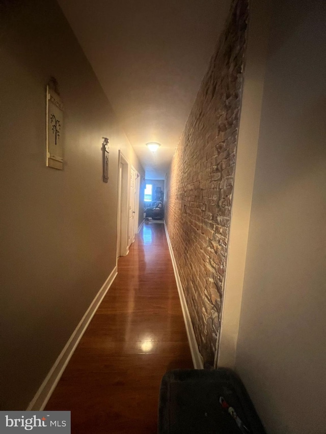 hall featuring baseboards and wood finished floors