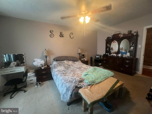 carpeted bedroom featuring a textured ceiling and a ceiling fan