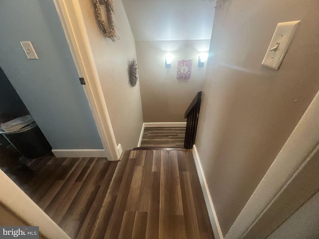 staircase with baseboards and wood finished floors