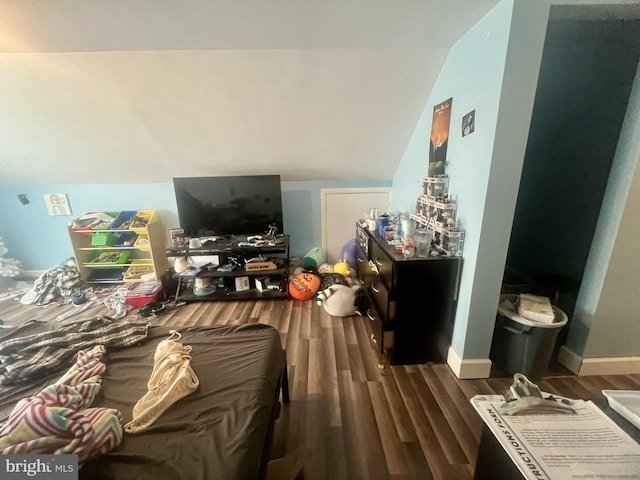 bedroom featuring baseboards, wood finished floors, and vaulted ceiling