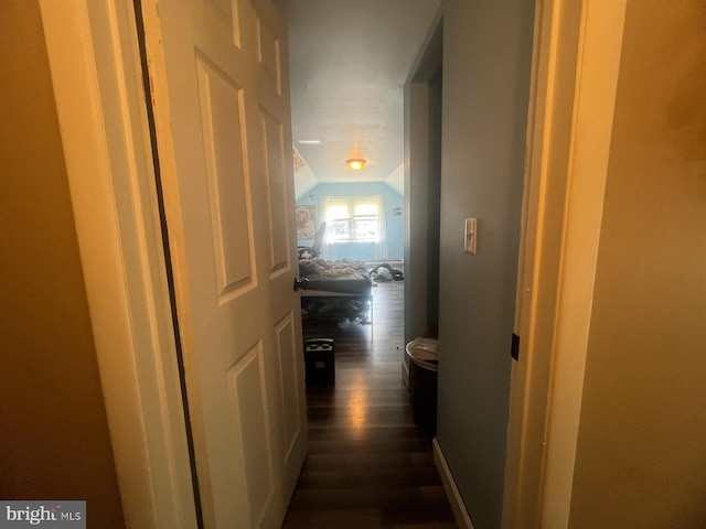 hall with vaulted ceiling and dark wood-style floors