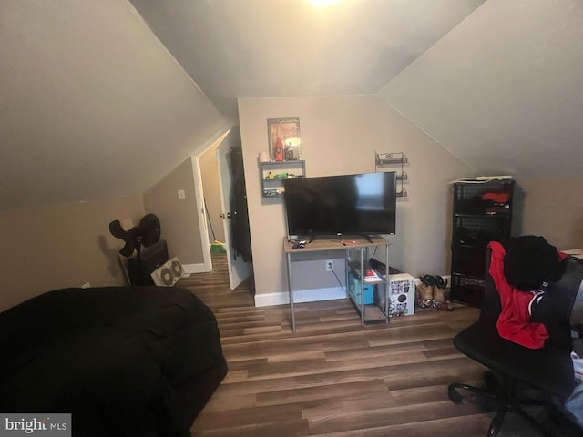 bedroom with baseboards, wood finished floors, and vaulted ceiling