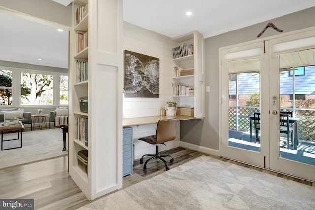 office with a healthy amount of sunlight, wood finished floors, and built in desk