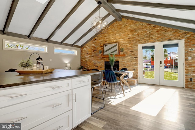 kitchen with dark countertops, plenty of natural light, white cabinets, and french doors