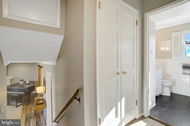 stairway with tile patterned flooring and tile walls