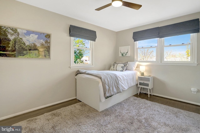 bedroom with a ceiling fan, wood finished floors, and baseboards