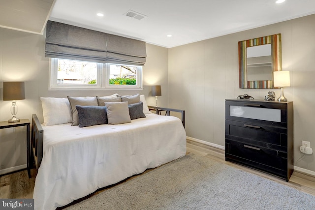 bedroom with recessed lighting, visible vents, baseboards, and wood finished floors