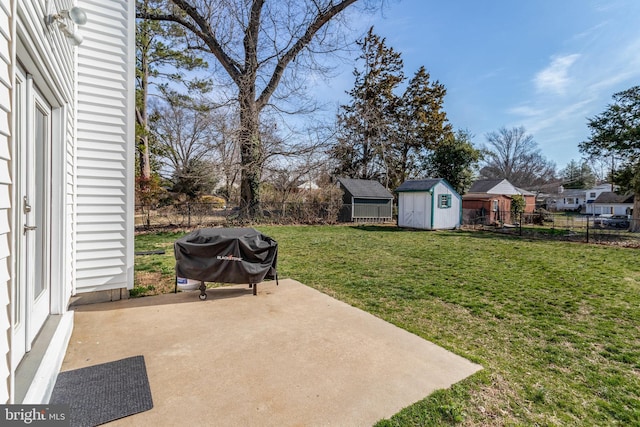 view of yard featuring an outbuilding, a storage shed, a fenced backyard, and a patio area