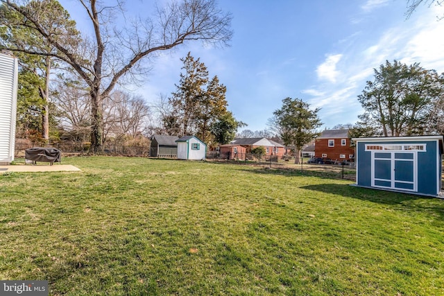 view of yard featuring an outbuilding, a shed, and fence