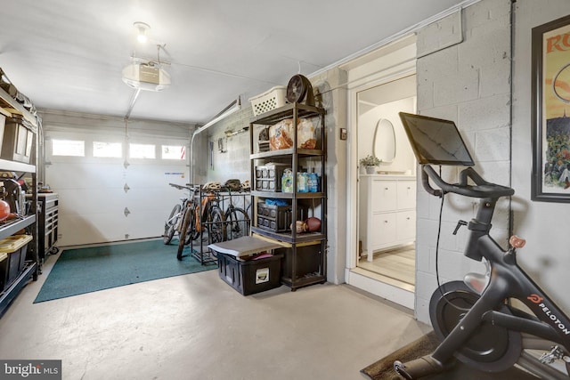 exercise room with concrete block wall and a garage