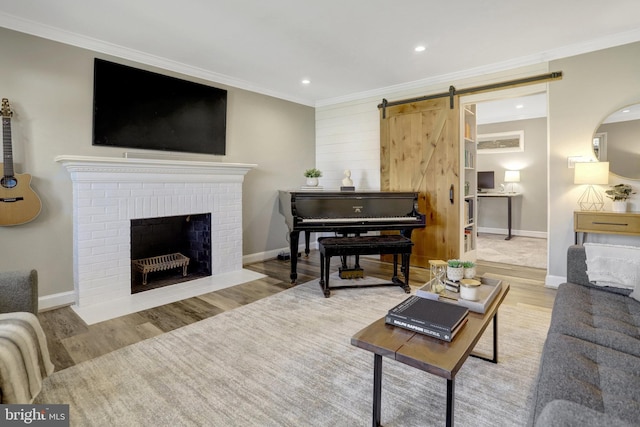 living area featuring ornamental molding, a barn door, and wood finished floors