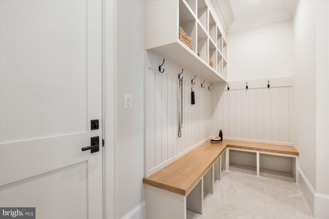 mudroom featuring marble finish floor, crown molding, and baseboards