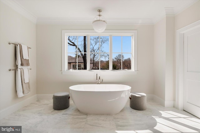 bathroom featuring crown molding, a freestanding tub, baseboards, and marble finish floor