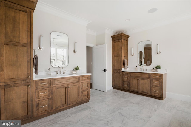 full bathroom featuring a sink, baseboards, two vanities, and crown molding