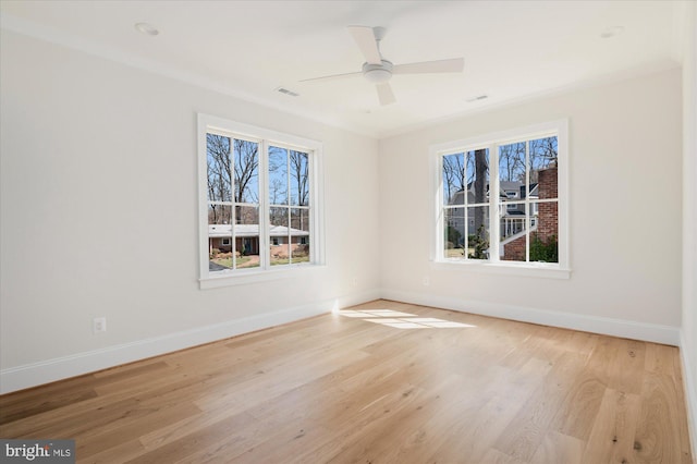 spare room with visible vents, baseboards, and wood finished floors