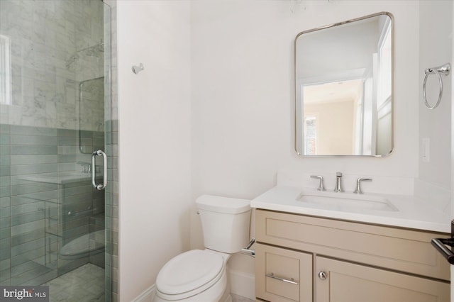 bathroom featuring vanity, a shower stall, and toilet