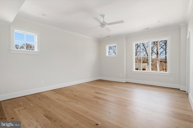 empty room featuring light wood-style flooring, a ceiling fan, crown molding, and baseboards