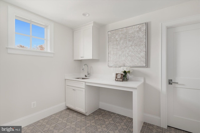 interior space featuring baseboards and a sink