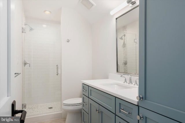 bathroom featuring visible vents, vanity, toilet, and a shower stall