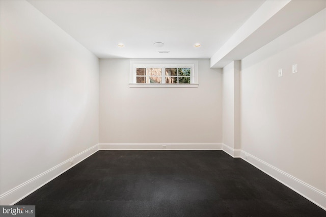 spare room with recessed lighting and baseboards