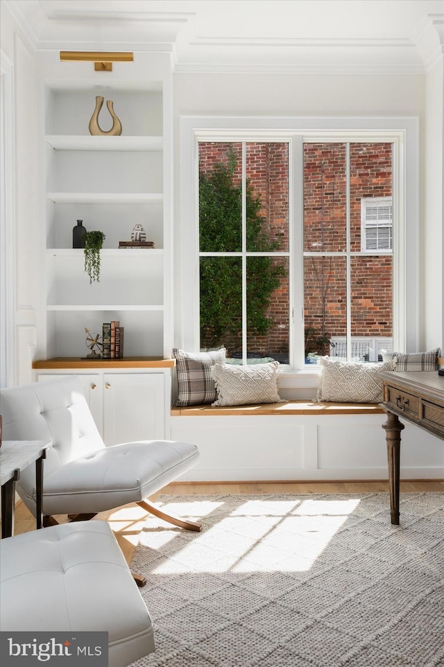 sitting room featuring built in features and ornamental molding